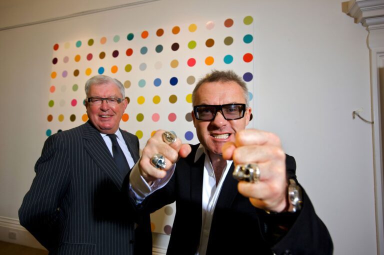 Artist Damien Hirst, whose paintings are listed on the artwork pricing database of art investment platform Masterworks, with his business manager Frank Dunphy pictured with some of his artworks. Martin Beddall / Alamy Stock Photo