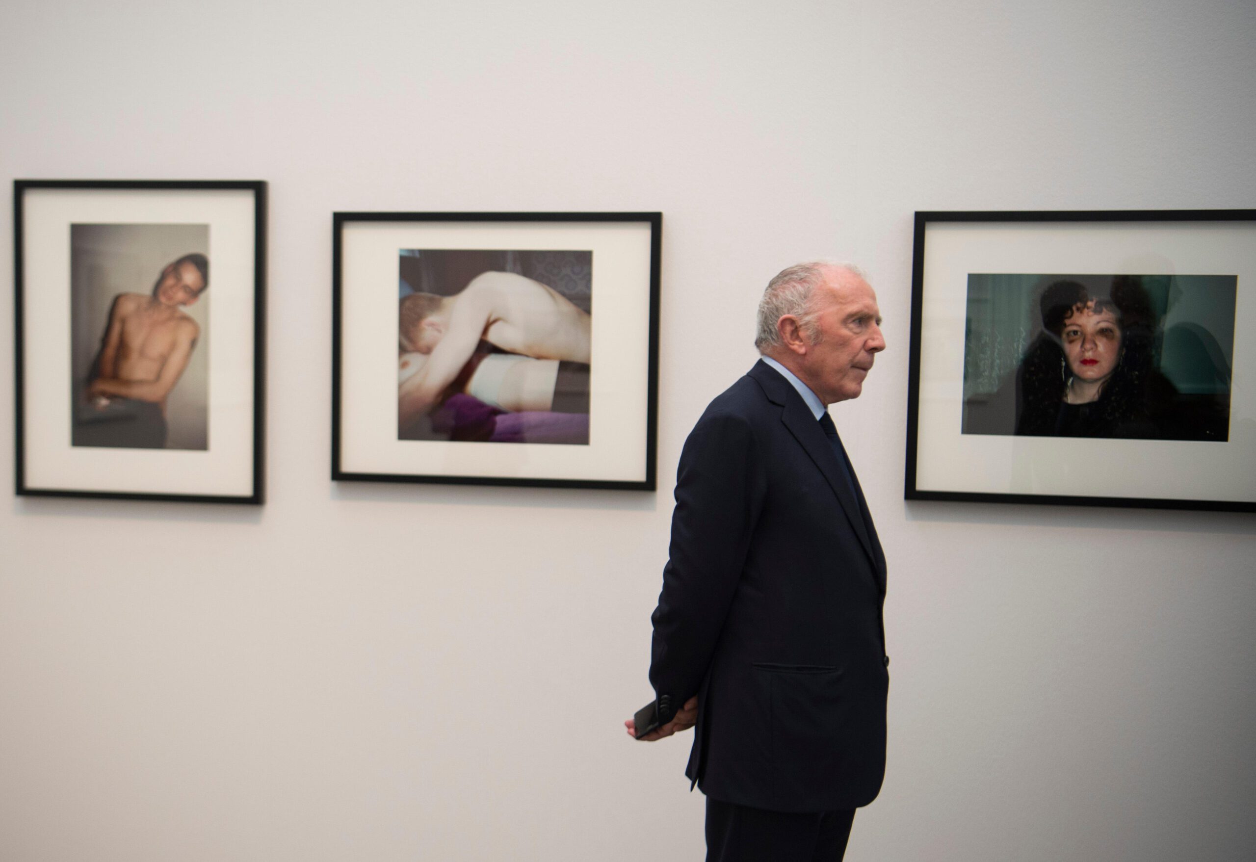 Pinault Collection owner Francois Pinault seen in front of works by US photographer Nan Goldin. dpa picture alliance / Alamy Stock Photo