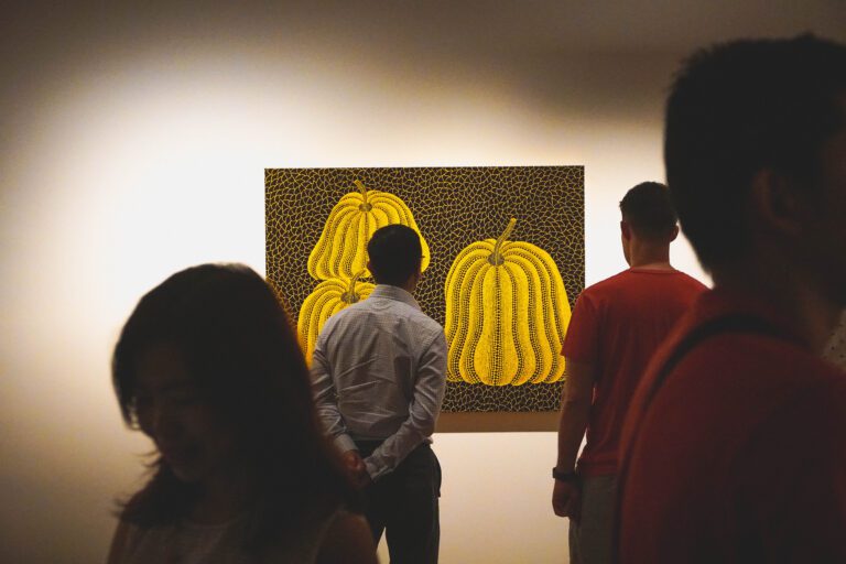 A visitor looking at one of Yayoi Kusama’s exhibit at her exhibition in Singapore. Photo by Mujiri on Shutterstock