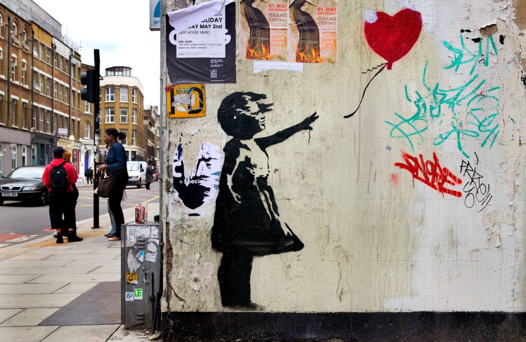 Banksy stencil of girl with heart, London, UK