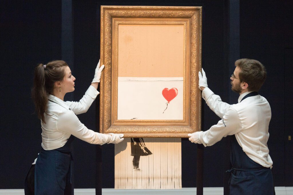 London, UK. 12th Oct, 2018. Sotheby's staff members present Banksy's "Love is in the Bin" in London, Britain on Oct. 12, 2018. Originally titled "Girl with Balloon", the British street artist Banksy made his painting self-destruct on Oct. 5 moments after it was auctioned for 1.042 million British pounds (1.37 million U.S. dollars) at Sotheby's in London. Credit: Ray Tang/Xinhua/Alamy Live News
