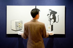  A sales assistant holds a diptych canvas entitled ?Monkey Detonator? by Banksy / Alamy Live News